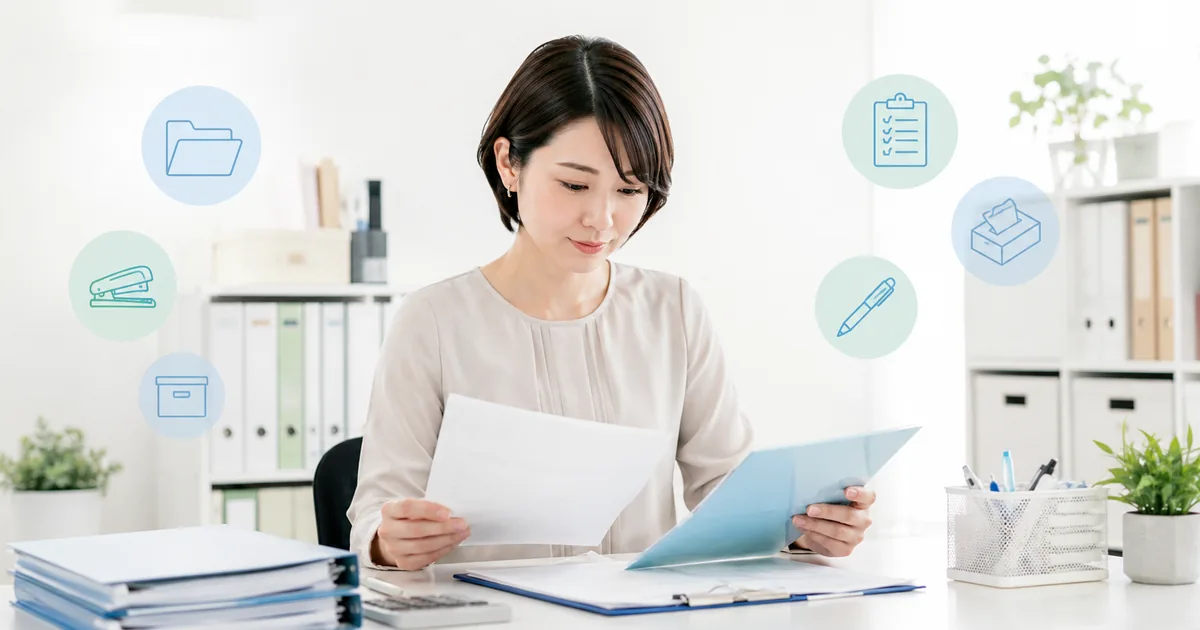 備品台帳と書類を確認する中小企業の総務担当者
